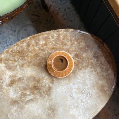 A simple, smooth stone resting on a wooden surface.